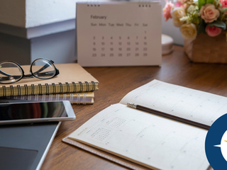 Organized desk with computer, phone, notebooks, planners and flowers symbolizing financial spring cleaning with faith.