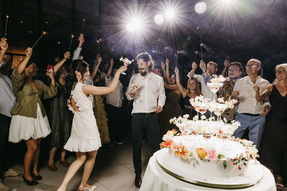 Couple dancing at a celebration with guests cheering.