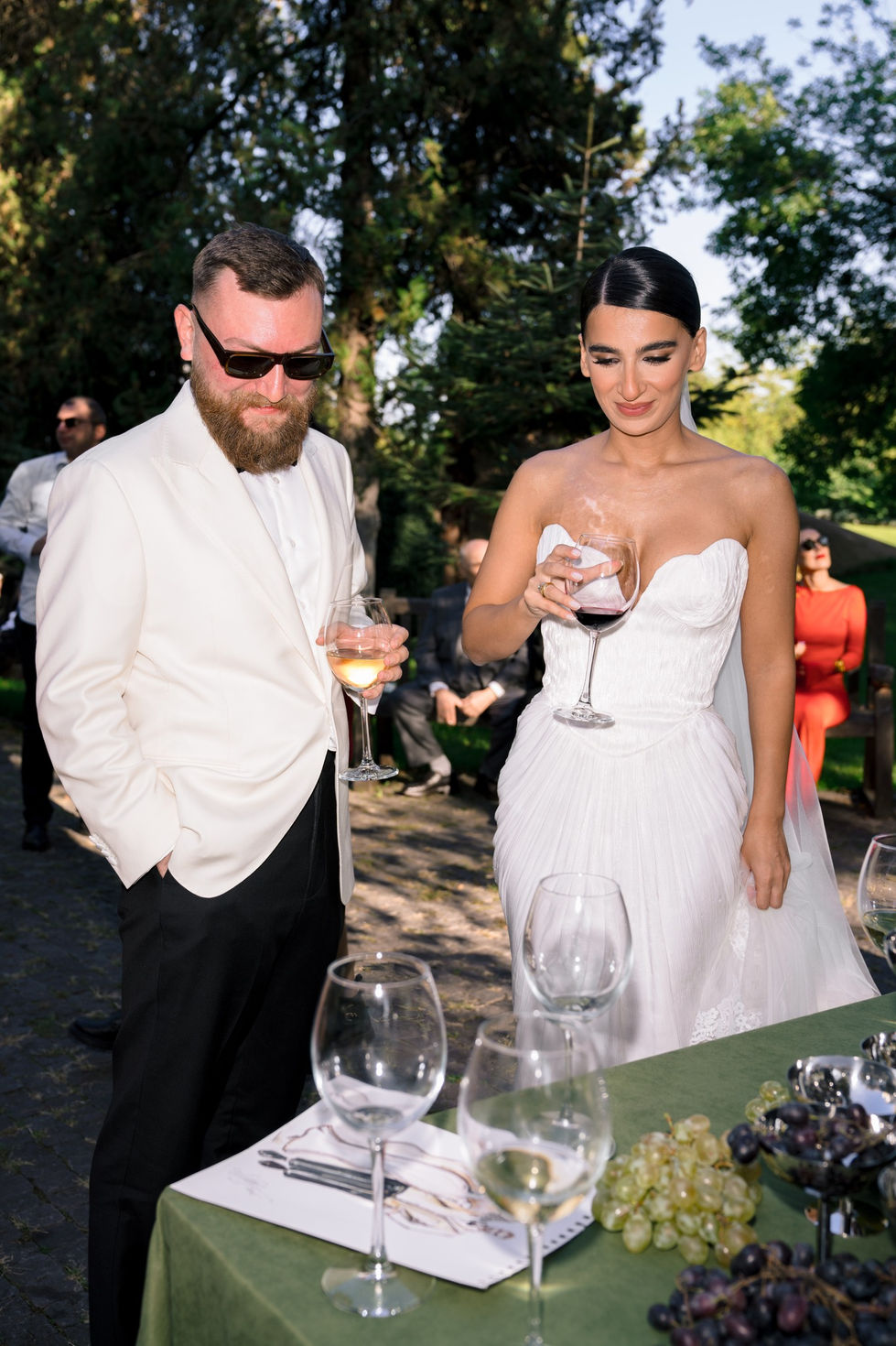 Man and woman in formal attire with wine glasses.