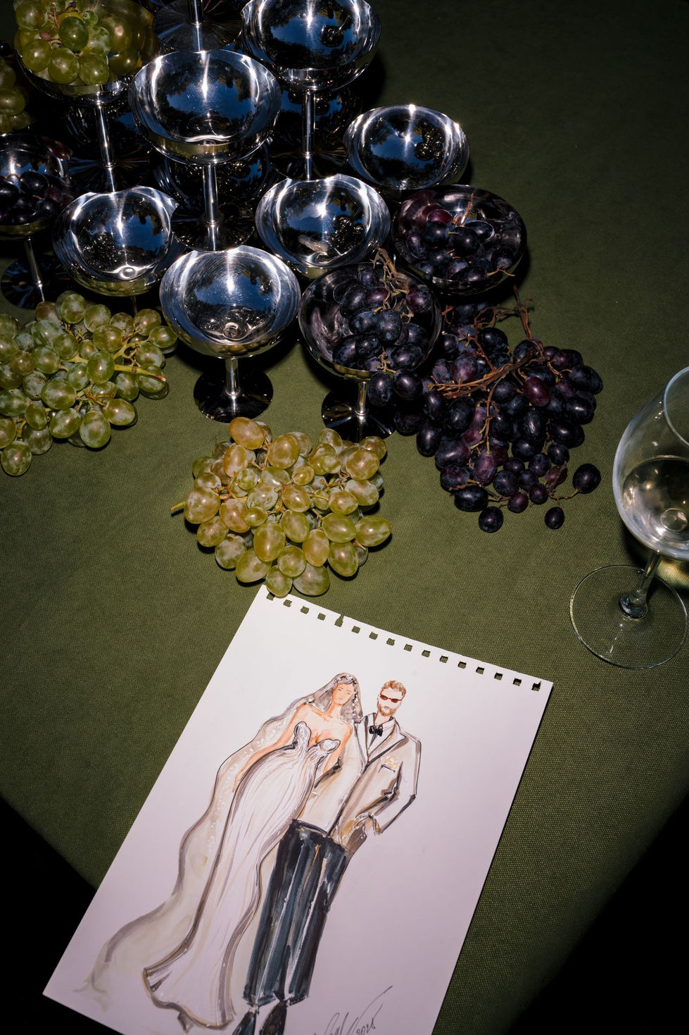 Illustration of couple with grapes and wine glasses.