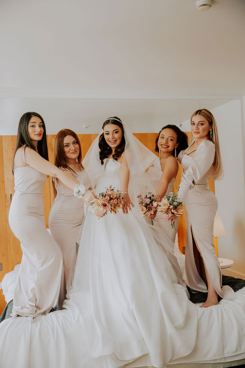 Group of bridesmaids in matching robes preparing for the wedding day.