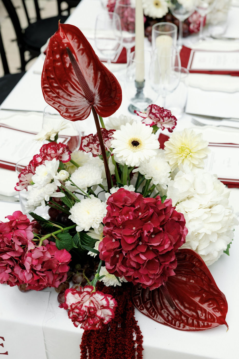Red and white floral arrangement on table.