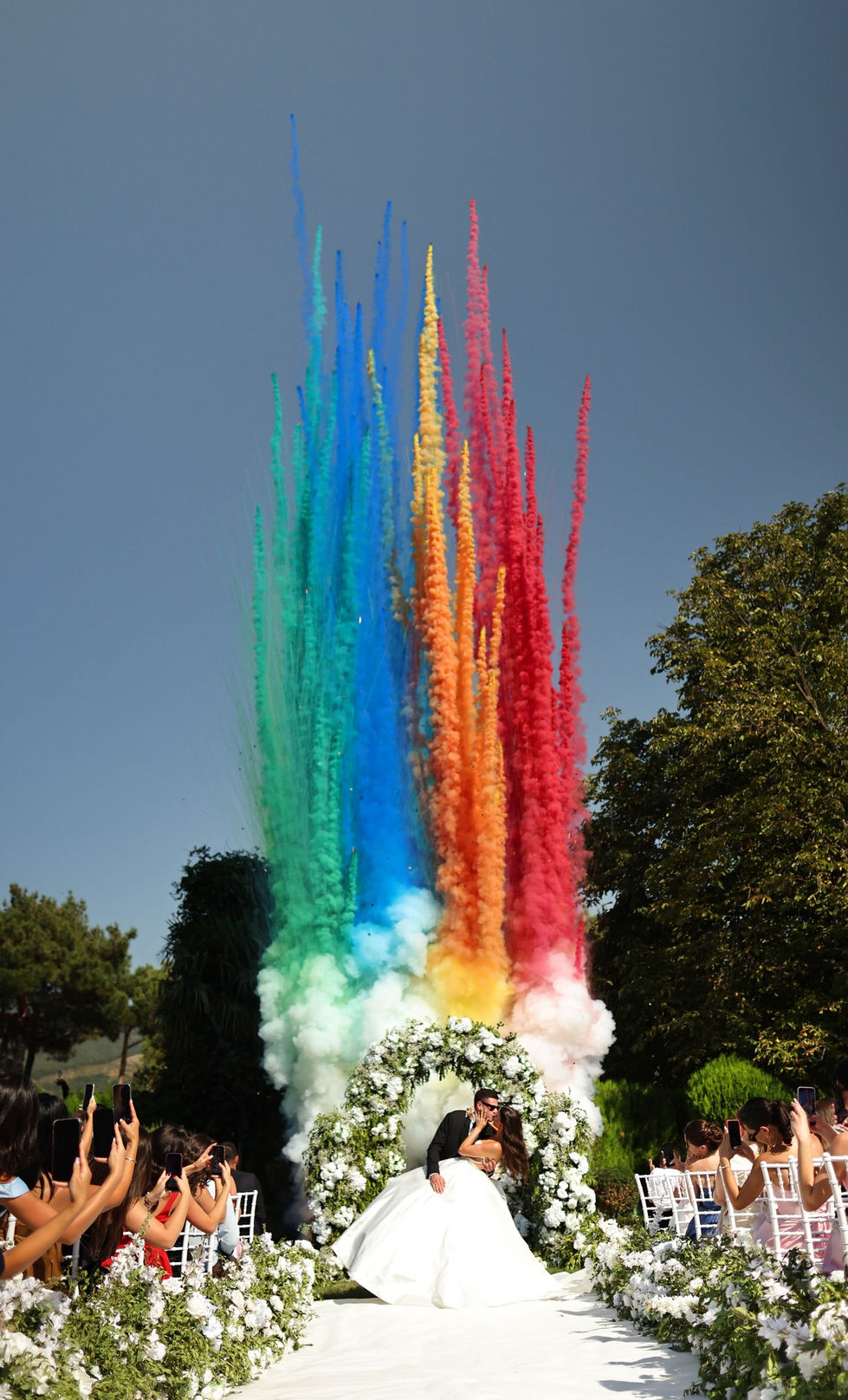 Colorful smoke plumes rising in outdoor setting.