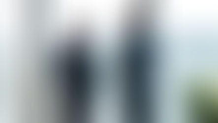 Two CFO's in discussion by an office window