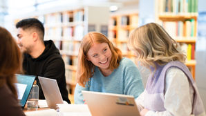 Studenter som pluggar i ett bibliotek 