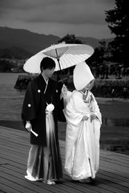 Couple en tenues de mariage japonaises traditionnelles sous un parapluie