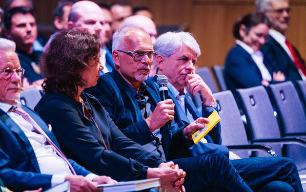 Ein Gast im Publikum stellt eine Frage