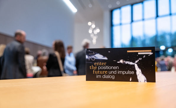 Ein Flyer von enter the future 13 liegt auf einem Stehtisch im Foyer der TauberPhilharmonie