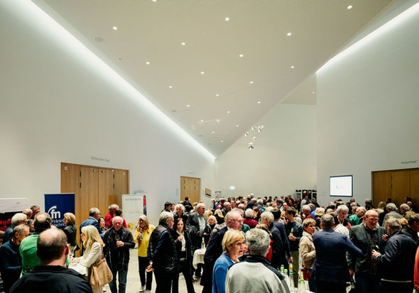 Blick in das mit Menschen gefüllte Foyer der TauberPhilharmonie