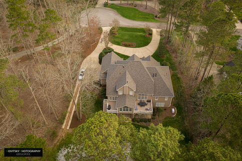 Drone photo of large home on wooded lot with winding driveway — Novitsky Photography