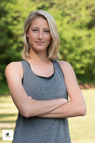 Woman with arms crossed in sporty tank top.