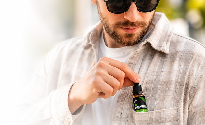 Mann mit CBD Öl Tropfen von Unser Kraut Österreich