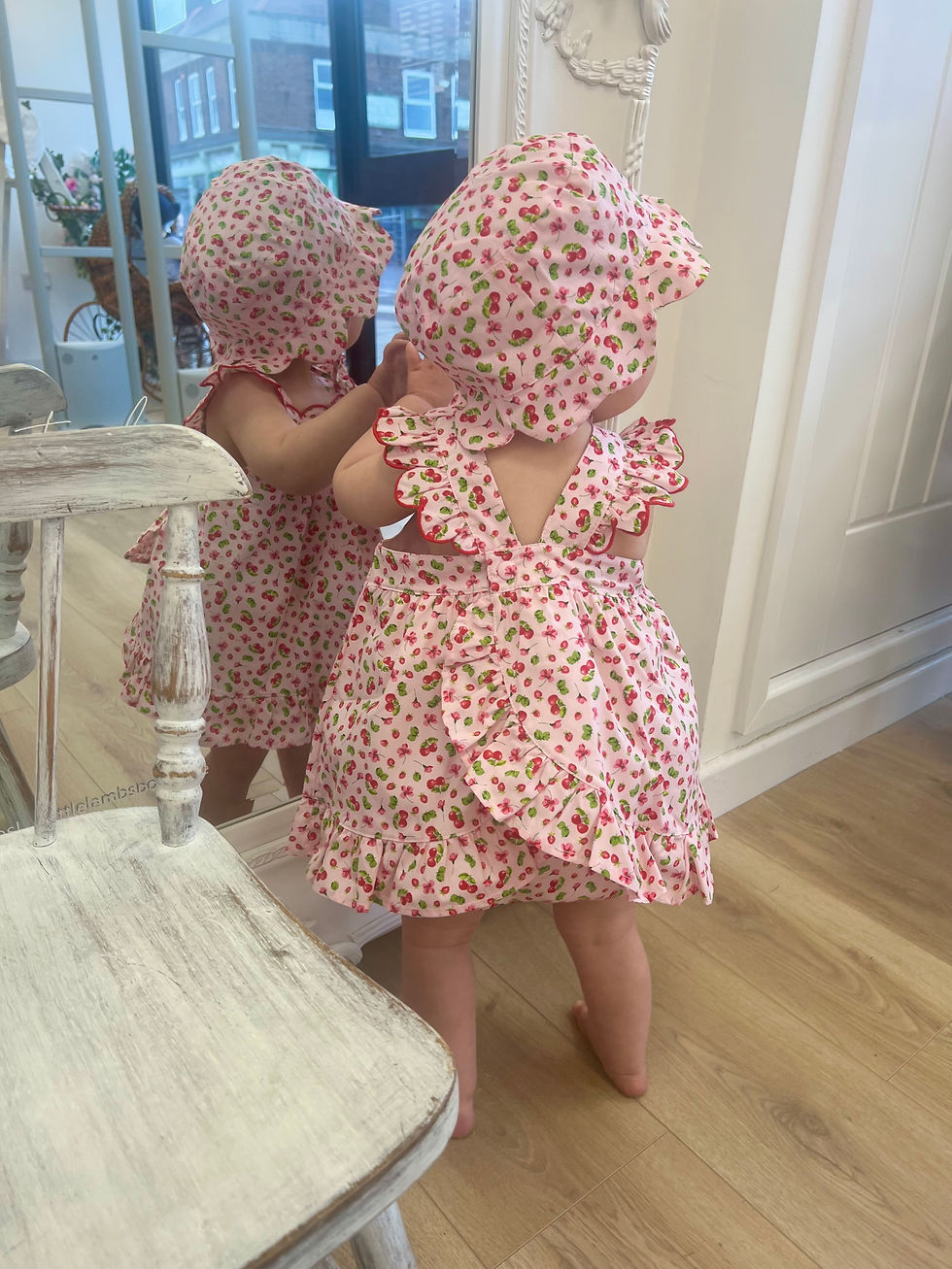 Deolinda girls swing back dress and jampant set. In a pink material with red cherries, strawberries and floral print.