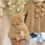 Thumbnail: Little Nosh beige double knit jacket and pom hat with cable knit detailing, bows and pom pom fastening