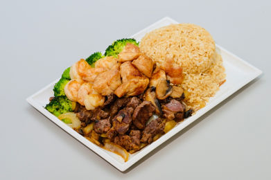 Plate of rice, chicken, beef, shrimp, and broccoli