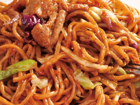 Close-up of stir-fried noodles with meat and vegetables, ready to eat.
