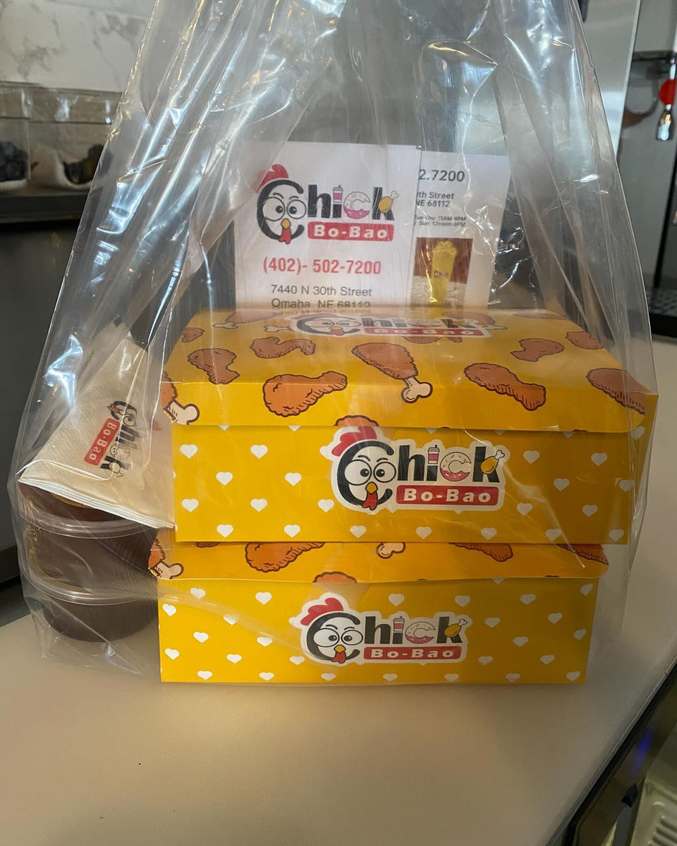 Chick-N-Pizza 炸鸡披萨餐盒的特写，纸袋，黄色盒子和文字。