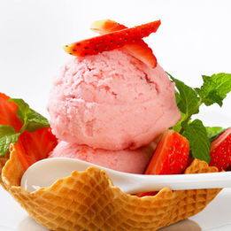 Strawberry ice cream with berries and mint in a waffle bowl