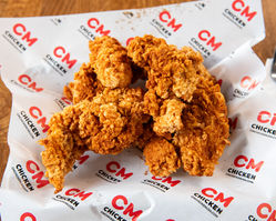 Crispy fried chicken tenders on CM Chicken paper, delicious takeout meal.