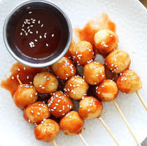 一盘炸丸子配蘸酱,浇上芝麻,美味可口,诱人食欲