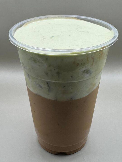 Layered iced matcha drink with chocolate base and creamy green foam.