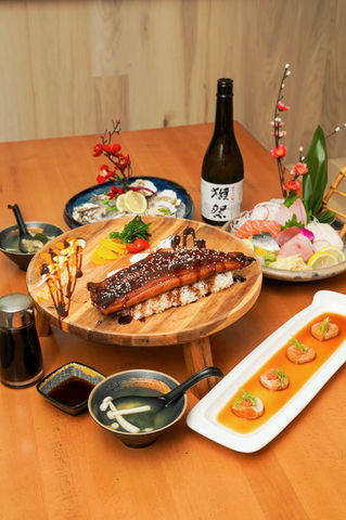 Various sushi dishes on a wooden table, Yoi Sushi restaurant selection.