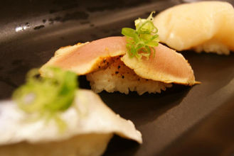 美味寿司特写,配有葱花,摆放在黑色盘子上,诱人的日式料理。