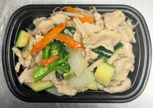 Chicken stir fry with vegetables in a black container, ready to eat.