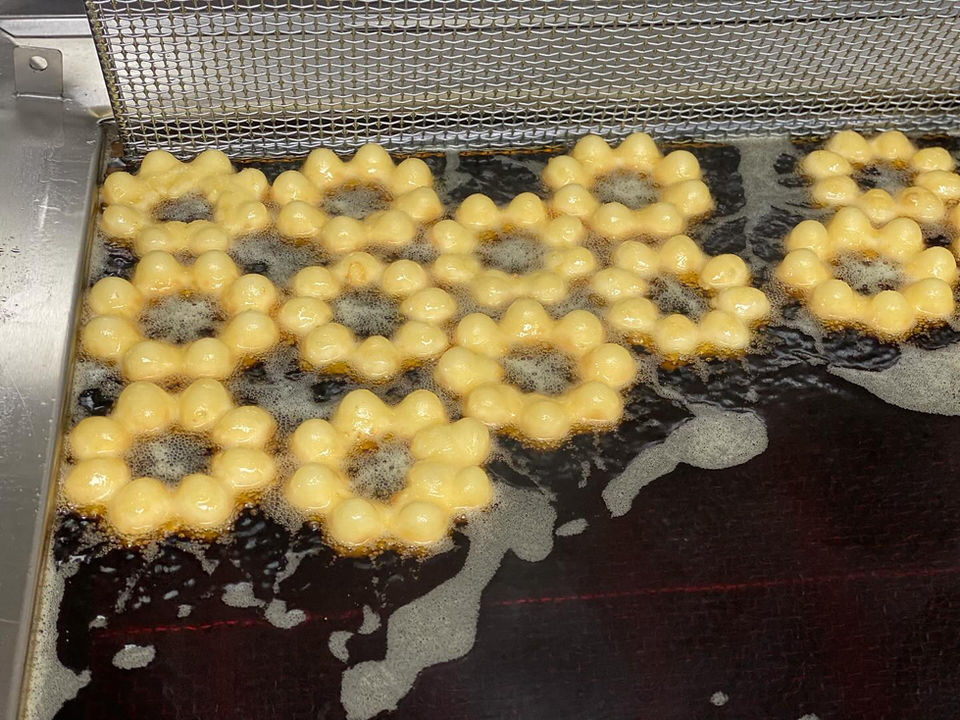 炸花形甜甜圈在油炸，美食烹饪过程，美味诱人的食物，甜点。