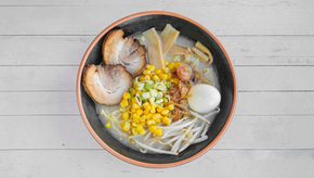 一碗美味的拉面,配有玉米、鸡蛋、肉和蔬菜。 HOME