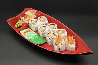 Tempura shrimp sushi rolls with "WASABI" packet, ginger on red boat.