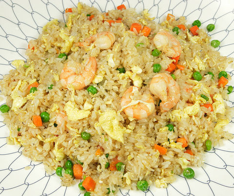 Shrimp fried rice with peas, carrots, and eggs on a white plate. Teriyaki Plus