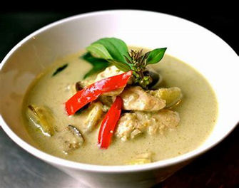 碗里的美味绿色咖喱菜肴,配有辣椒和罗勒。 美食摄影。