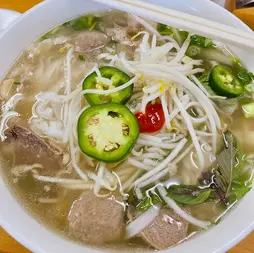一碗美味的鸡肉粉面，配有蔬菜和辣椒。 Chicken pho you