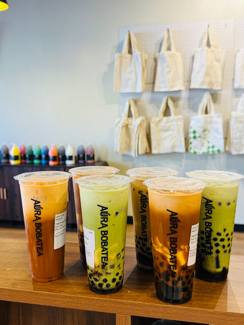 Various boba tea drinks from Adira Bobatea store, with visible text on cups.