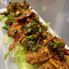 Delicious fried chicken with green peppers and chili peppers on a plate.