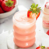 草莓饮料,草莓装饰,玻璃杯位于白色大理石板上,新鲜草莓作为背景。