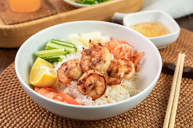 Grilled shrimp rice bowl with cucumber, lemon, and pickled vegetables.
