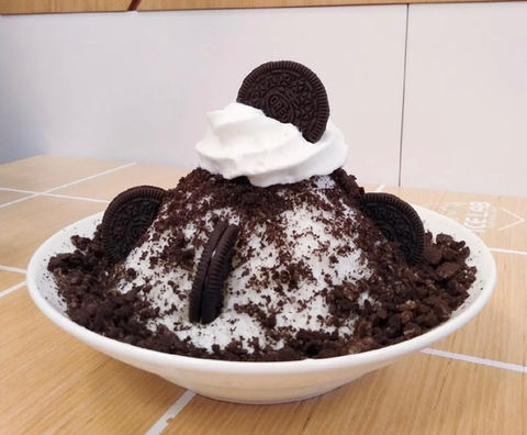 Oreo cookie dessert with whipped cream and crushed Oreos in a bowl.