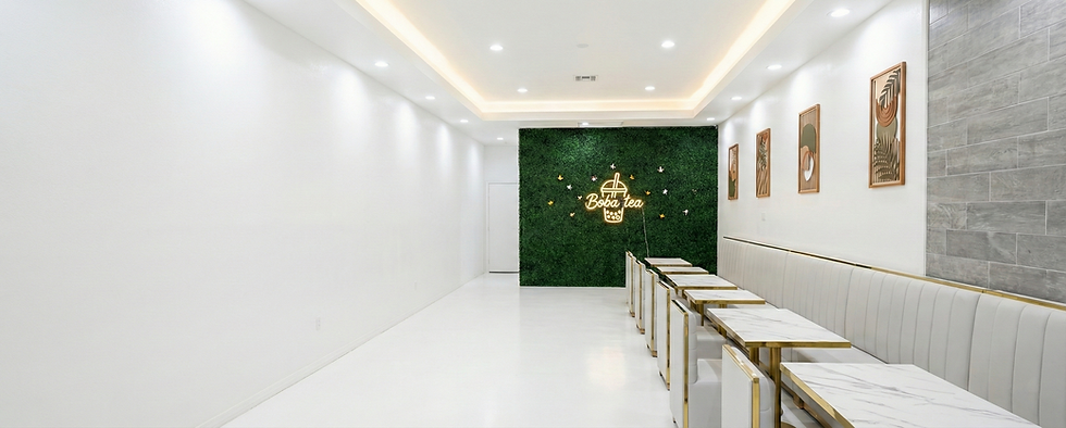Interior view of a modern cafe with tables, art, and decorative wall.