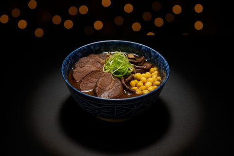 碗里的牛肉拉面，配有玉米、蘑菇和葱花，在黑暗中发光。