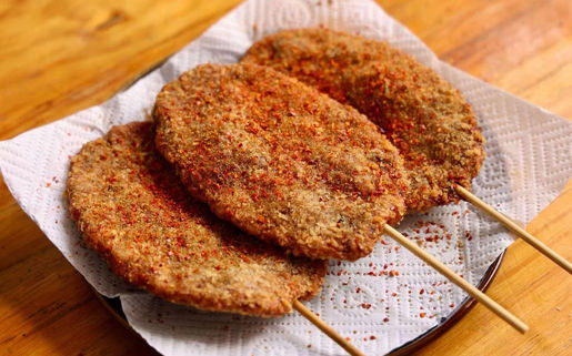 Three fried skewers with paprika on a paper towel, Yang Sao 杨嫂炸串.