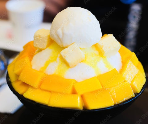 Mango shaved ice dessert with ice cream and mango chunks food court.