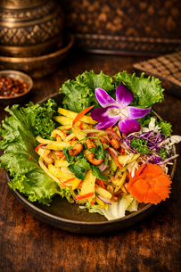 Mango salad with cashews, lettuce, and an orchid