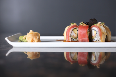 寿司卷在白盘子上,还有姜和芥末,一道美味的日本料理