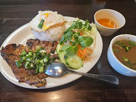 Grilled pork, fried egg, rice, and salad with side soup.