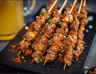 Grilled skewers of meat, close-up shot on a black plate, Yang Sao 杨嫂炸串.