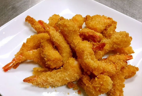 Golden fried shrimp on a white plate, delicious and ready to eat.