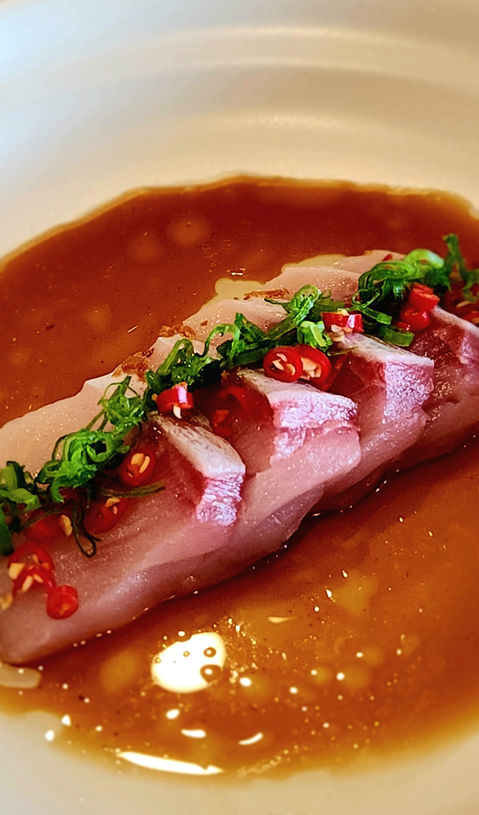 Sliced raw fish with sauce, chilis and green onions. Sushi The Classic