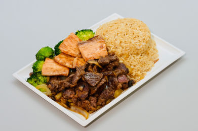 Sautéed beef, grilled salmon, rice, and broccoli on a plate